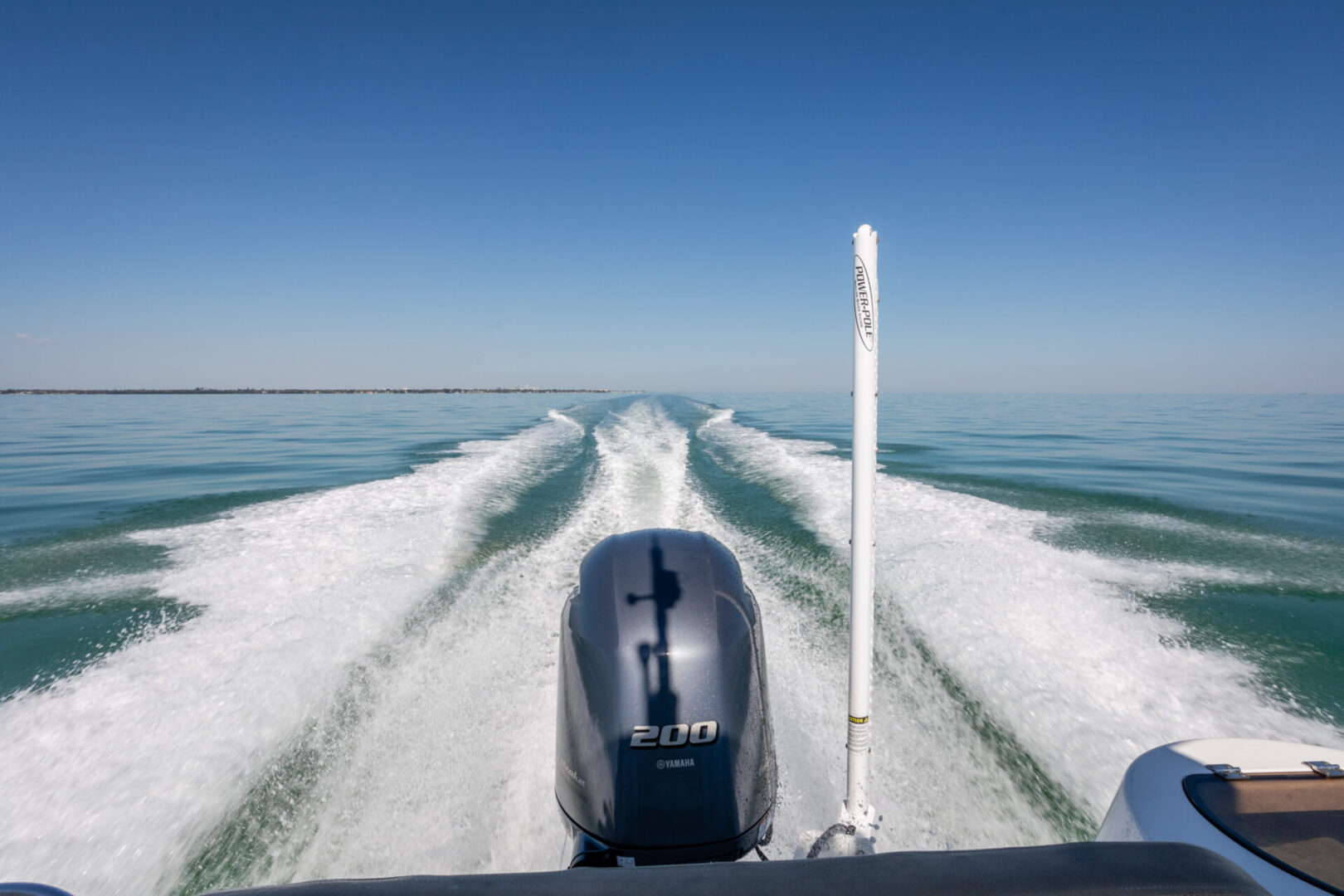 A boat is going down the water on some kind of wave.