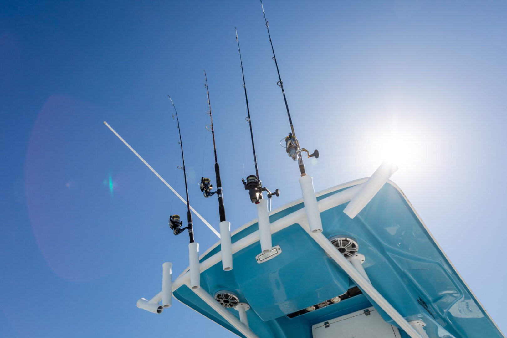 A blue boat with several fishing rods on it.