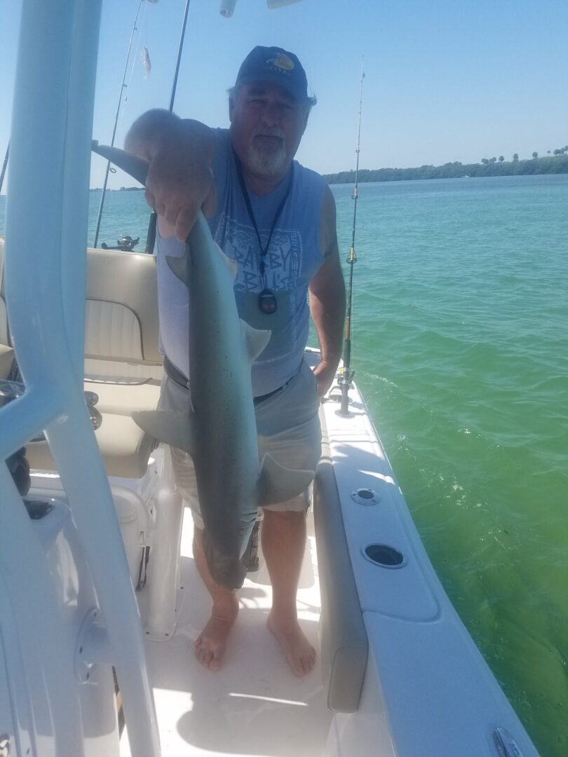 A man holding a fish on a boat