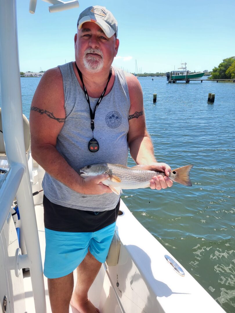 A man holding a fish on a boat